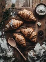 Delicious Freshly Baked Croissants with Butter and Jam on Wooden Board photo
