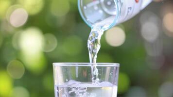 Refreshing Water Pouring into a Clear Glass on a Sunny Day photo