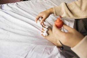 A person sitting on a bed with a red and white toothbrush photo