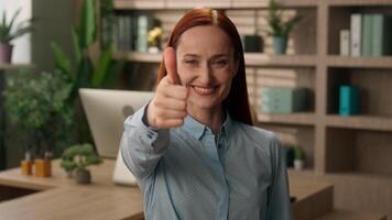 Caucasian business woman portrait female indoors smiling girl motivation happy businesswoman designer employer manager entrepreneur in office positive smile thumb up gesture good motivation recommend video