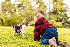 baby boy playing with a little dog in a park photo