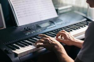 man playing piano with a music sheet photo