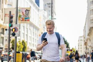 Young albino man using smartphone in the city photo