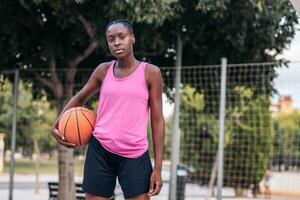 Confident Basketball Player Holding Ball with Determination photo