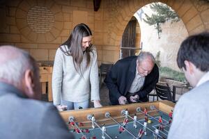 A granddaugther and his grandfather are playing table football game photo