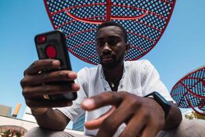 Black man using smartphone in city photo
