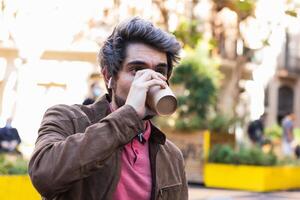 Man drinking coffee to go in city photo