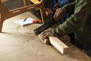 Joiner cutting wood with colleague measuring height photo
