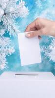 Hand placing paper into voting box with snowy winter background photo