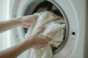 Hands Loading Laundry into Washing Machine for Home Cleaning Routine photo
