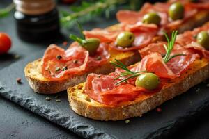 Tasty bruschetta with cured ham, olives and rosemary preparing for a party.. photo