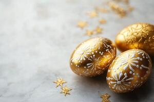 Golden easter eggs decorated with white ornaments and glitter stars on marble background photo