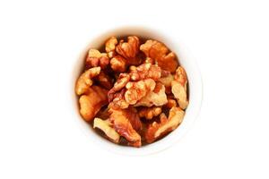 Peeled walnuts in a white bowl on a white background, isolated, Clipping path photo