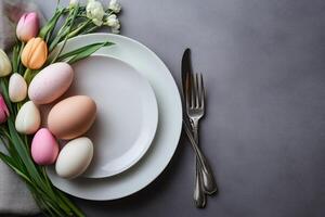 Easter table setting decorated with colorful eggs and tulips photo