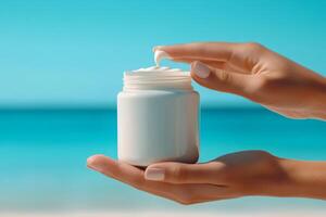 Woman holding moisturizing cream at the beach on sunny summer day photo