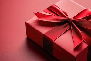 Elegant red gift box wrapped with beautiful bow on matching background photo