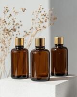 Three bottles of amber glass with gold tops photo