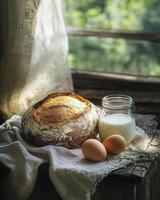 Bread, eggs and milk on a table by the window photo