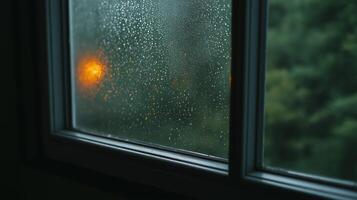Rainy Day Window View Rain Droplets on Glass, Orange Light, Blurred Green Background photo