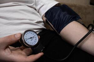 Blood pressure check up with manual tonometer, male hands close up photo