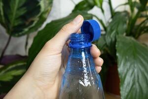 Recycled bottle with stationary plastic cap in womans hand photo