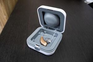 Hearing aid in grey cover on the table photo