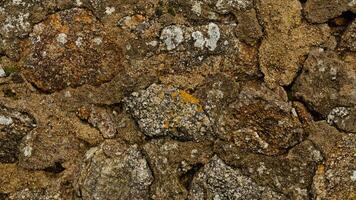 Texture of beige stone wall with rough masonry and uneven surface. Smooth, cracked surface. Old castle wall of stone different shape. Pattern with neutral colors. Minimal, stylish, trend concept photo