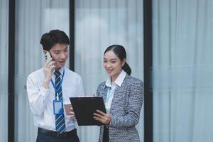 Asian business couple talking on the phone and looking at a tablet photo