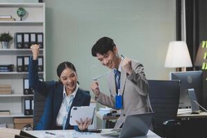 Two business people in an office with their hands up photo