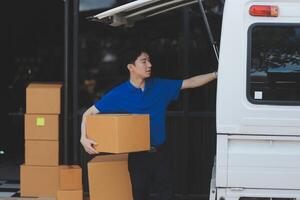 A man is standing next to a van with boxes photo