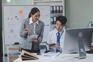 Two people in an office looking at a computer screen photo