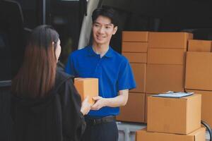 A man and woman are standing next to a van with boxes photo