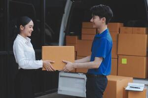 A man and woman are handing a box to another person photo