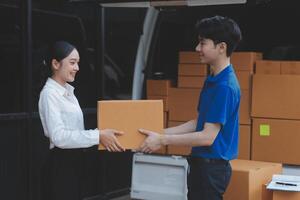 A man and woman are standing in front of a van with boxes photo