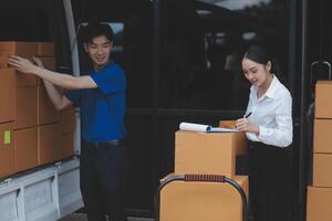 A man and woman are standing next to a moving van photo
