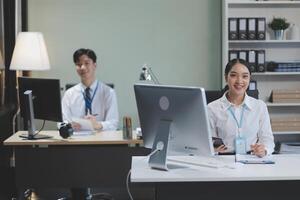 A woman and man sitting at a desk photo