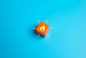 Burning flame on orange cube. Concept of hot offer, urgent message or profitable promotion. Exclusive discounts, marketing urgency, and flash sales. photo