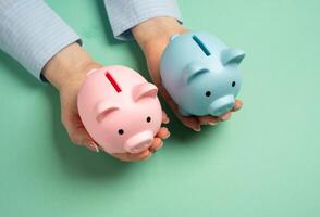 Two piggy banks of different sexes in outstretched hands. Combining household budgets. Merging finances, combining resources, and creating a shared budget in partnerships or family households photo