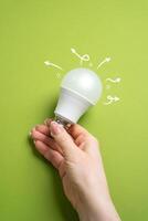 Idea and motivation for development. Light bulb in hand. Creativity, and innovation. Achieving success through inspired thinking. photo