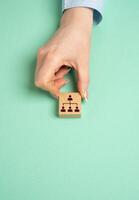 A hand holds a block with a symbol of hierarchy in a company or community. Leadership, organizational structure, and team coordination in businesses or communities. photo