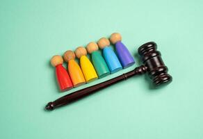 Figures of people of the LGBT community and the judge's hammer. Rights and freedoms, rules and freedoms. Quality, fairness, and societal acceptance in modern communities. photo