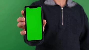 a man holding up a phone with a green screen. wall art mockup, mobile mockup, green screen mockup. video