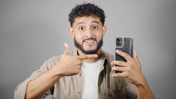 Man showing smartphone screen and pointing at it with finger video
