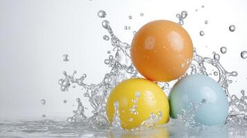 Colorful Bouncing Balls Creating Splash in Clear Water Against a Light Gray Background photo
