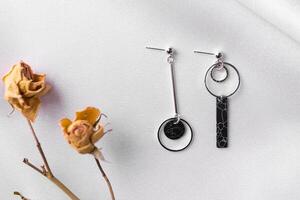 Female Jewelry. Vintage bijouterie jewelry. Beautiful handmade silver earrings on silk background. Flat lay, top view copy space and empty space for text photo