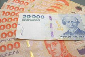 Stack of Argentine peso bills with twenty thousand peso bills on top photo