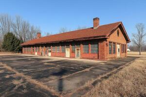 Abandoned Brick Building With Multiple Windows And Chimneys photo
