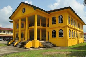 Yellow colonial style house with columns and arched windows photo