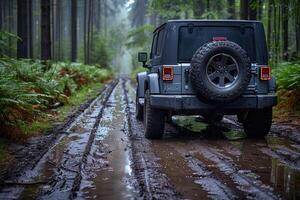 A grey SUV driving through a muddy forest road photo