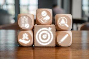 Wooden blocks with icons symbolizing agreement, teamwork, and business strategy on a wooden table. photo